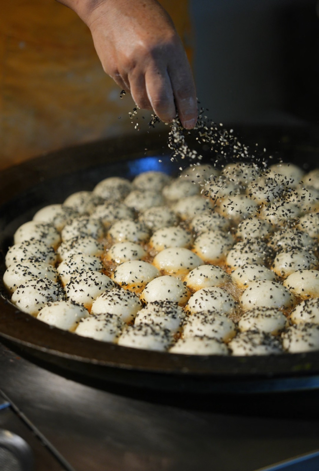 Freshly made pan-fried Beijing buns dusted with sesame