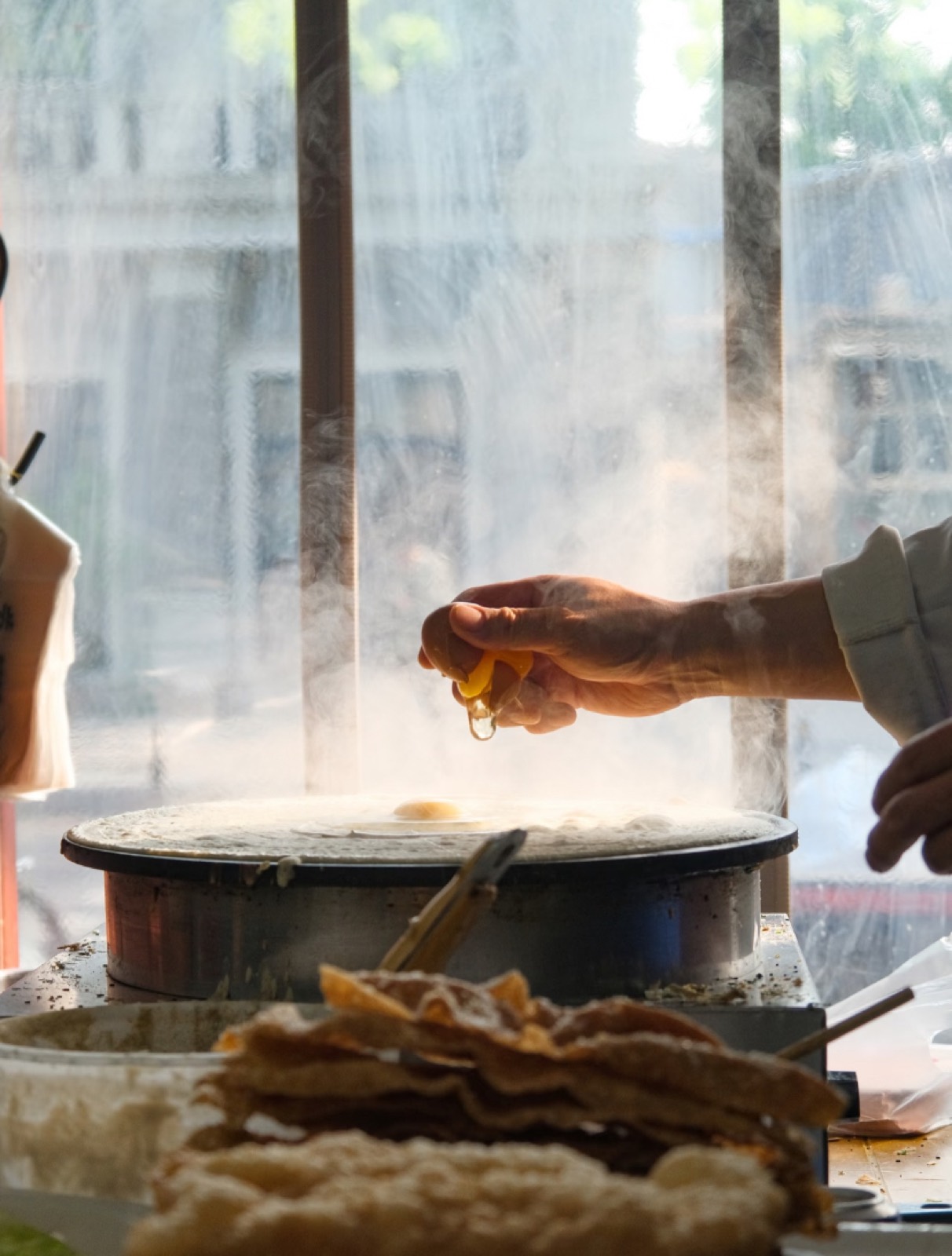 A jianbing crêpe being made on the griddle at a Beijing morning stall