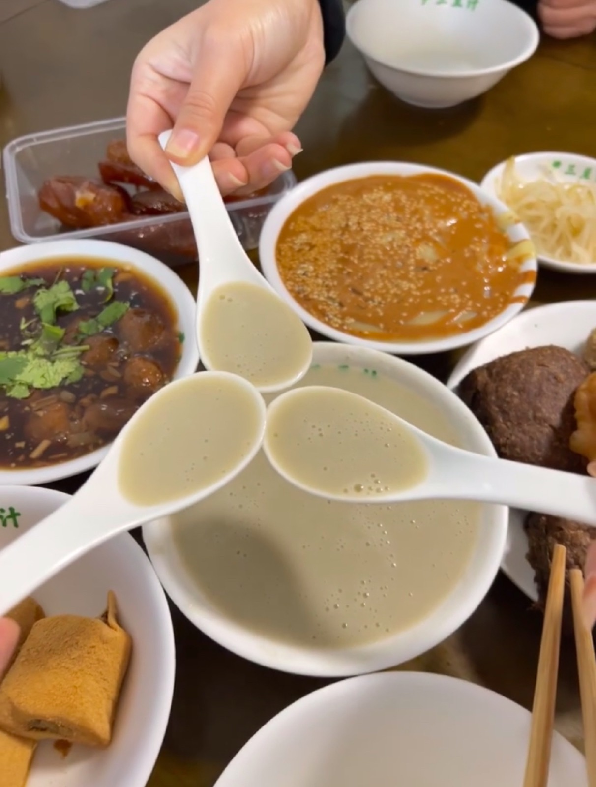 A shared Beijing breakfast spread of douzhi, pickles, and local morning dishes