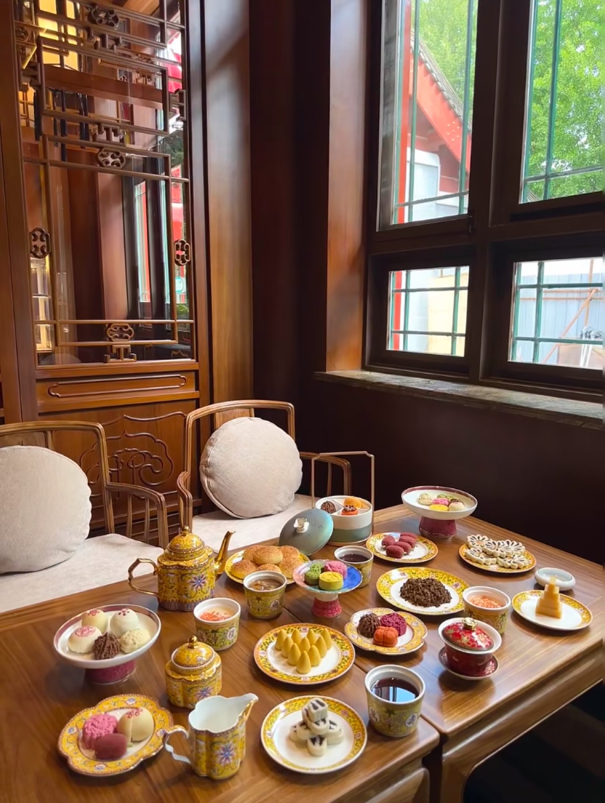 A spread of imperial-style Beijing pastries with yellow court teaware at Fangshan