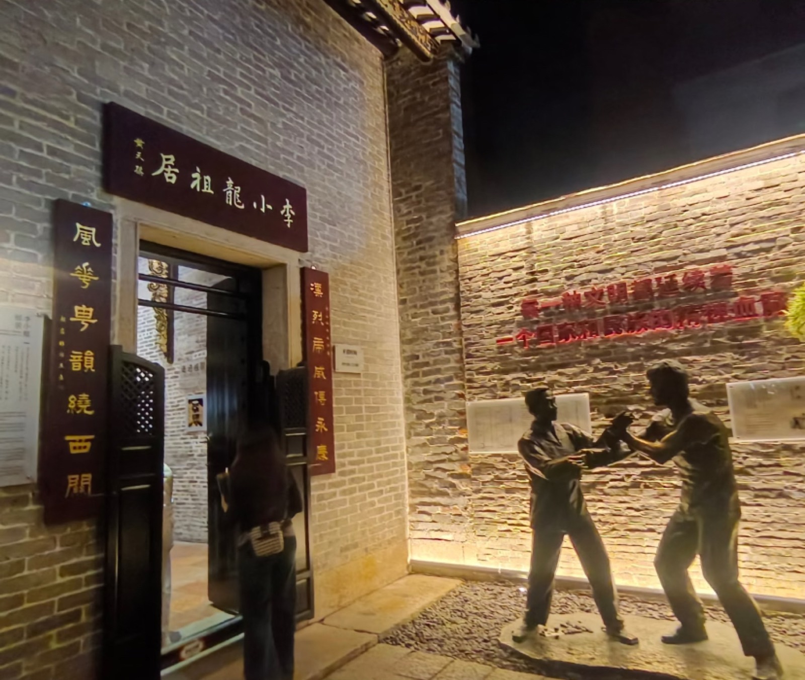 Bruce Lee's ancestral home lit up at night with kung-fu statues