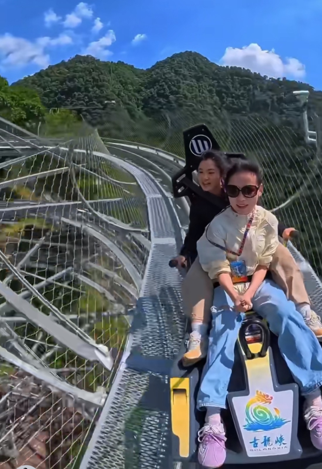 Riders on the cliff-side mountain coaster at Gulong Gorge