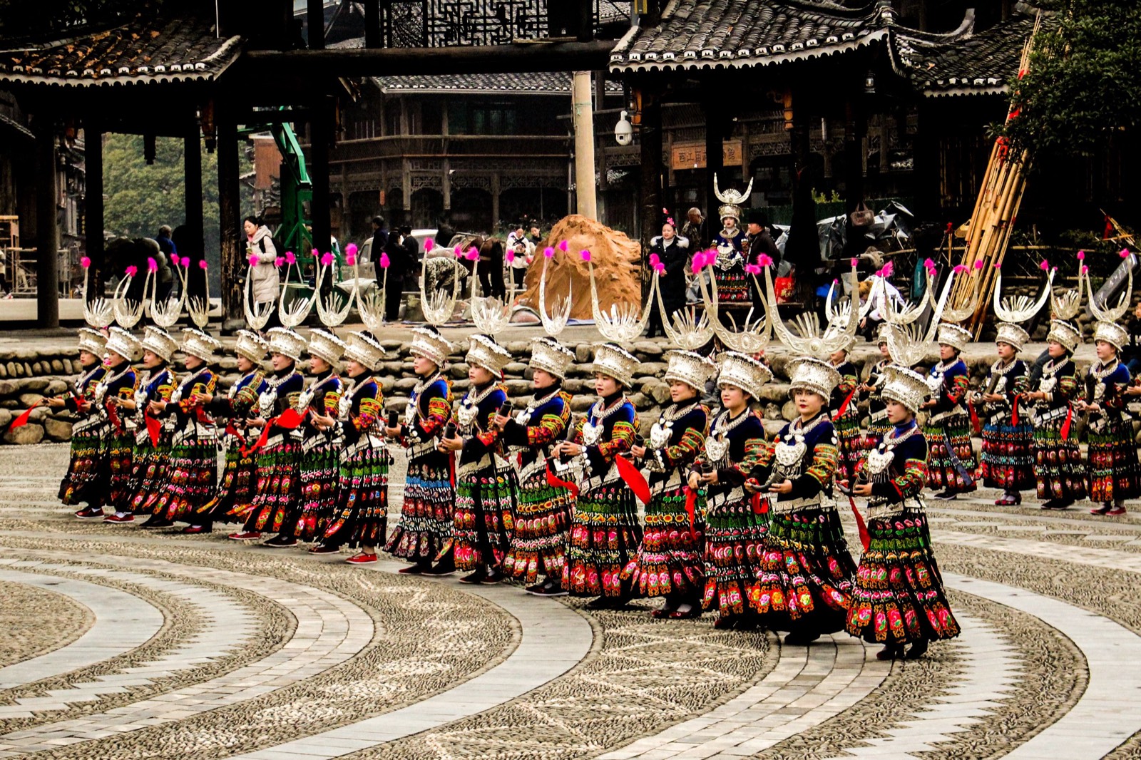 Hundreds of Miao women in silver headdresses dancing at a festival