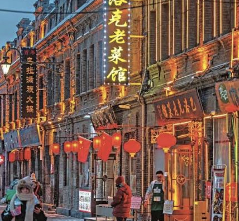 The historic Baroque architecture of Harbin's Central (Zhongyang) Street lit up on a snowy winter evening
