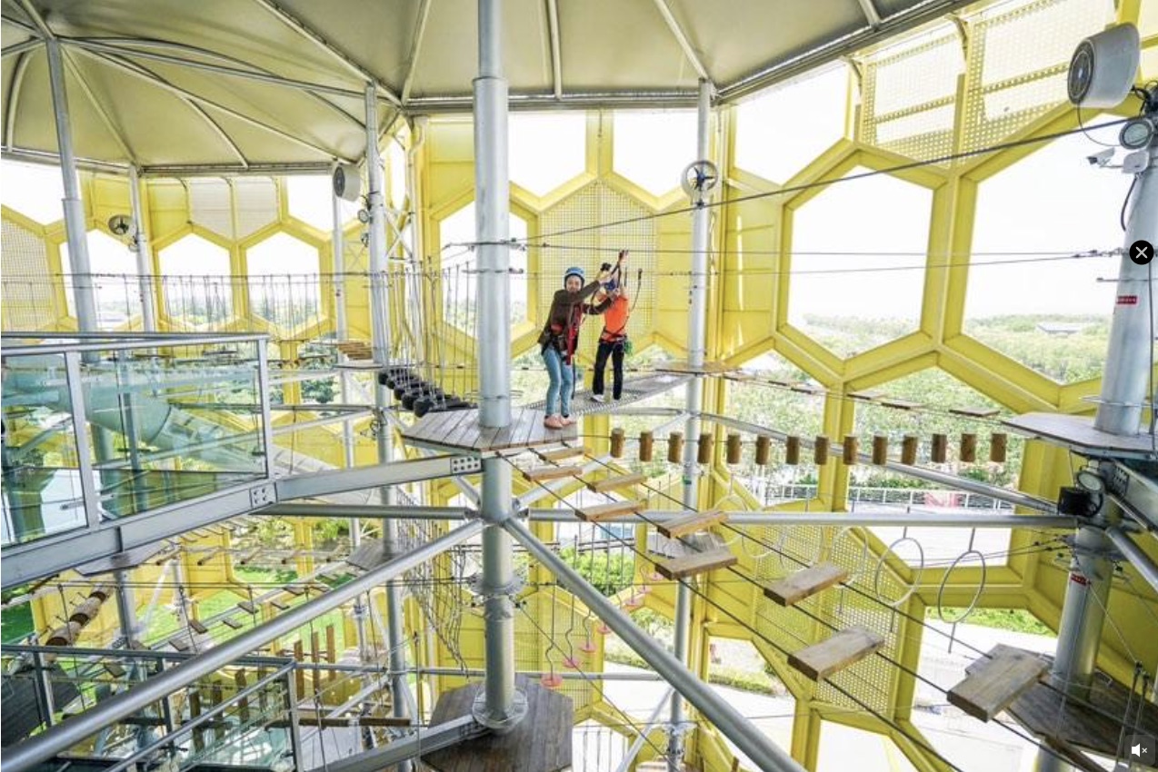 Children climbing the honeycomb tower challenge structure in the snow