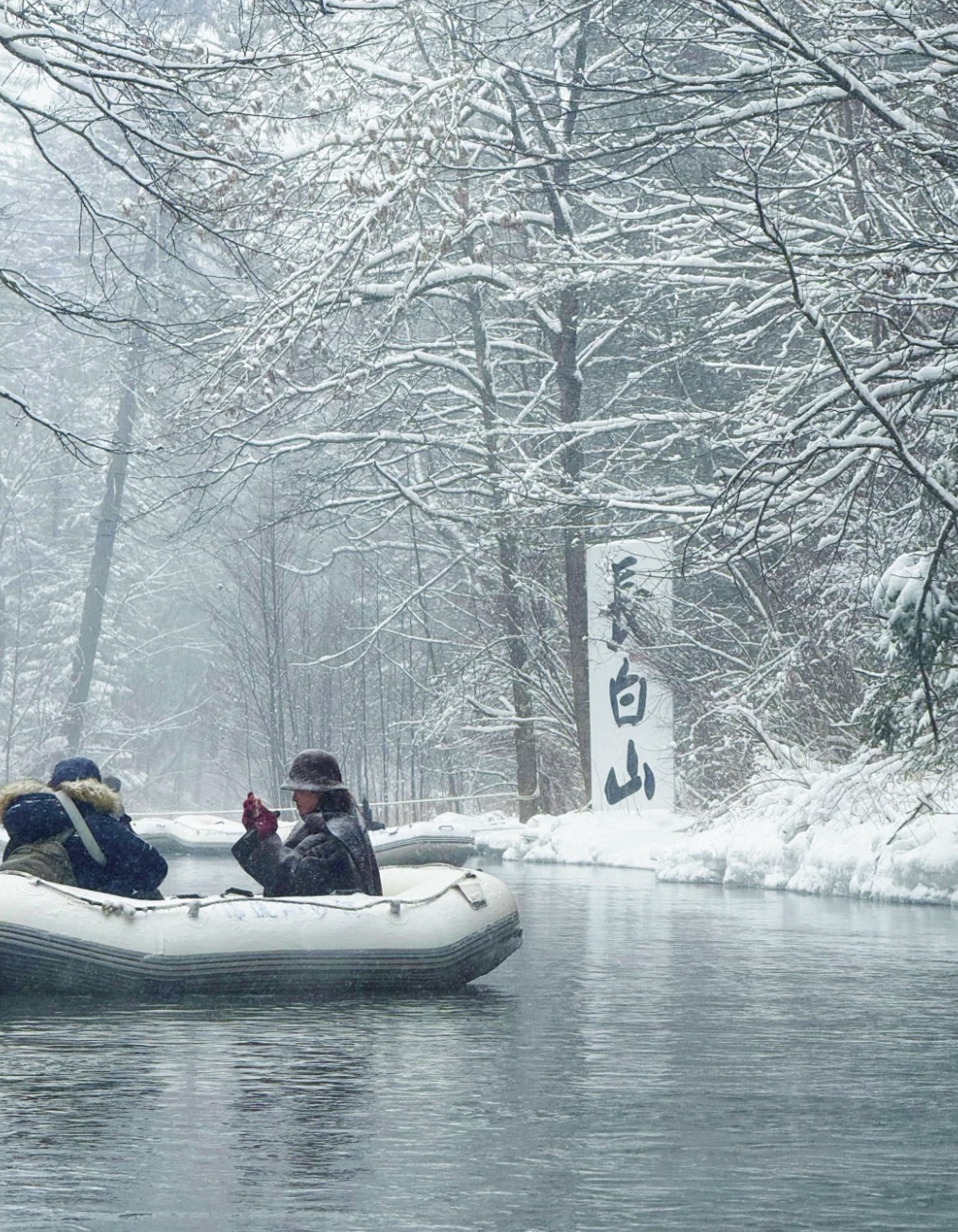 Rime-covered trees along a frozen river during a snow-forest drift at Changbaishan