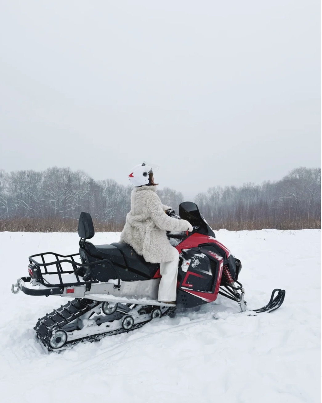 A family riding a snowmobile across fresh snow at Changbaishan