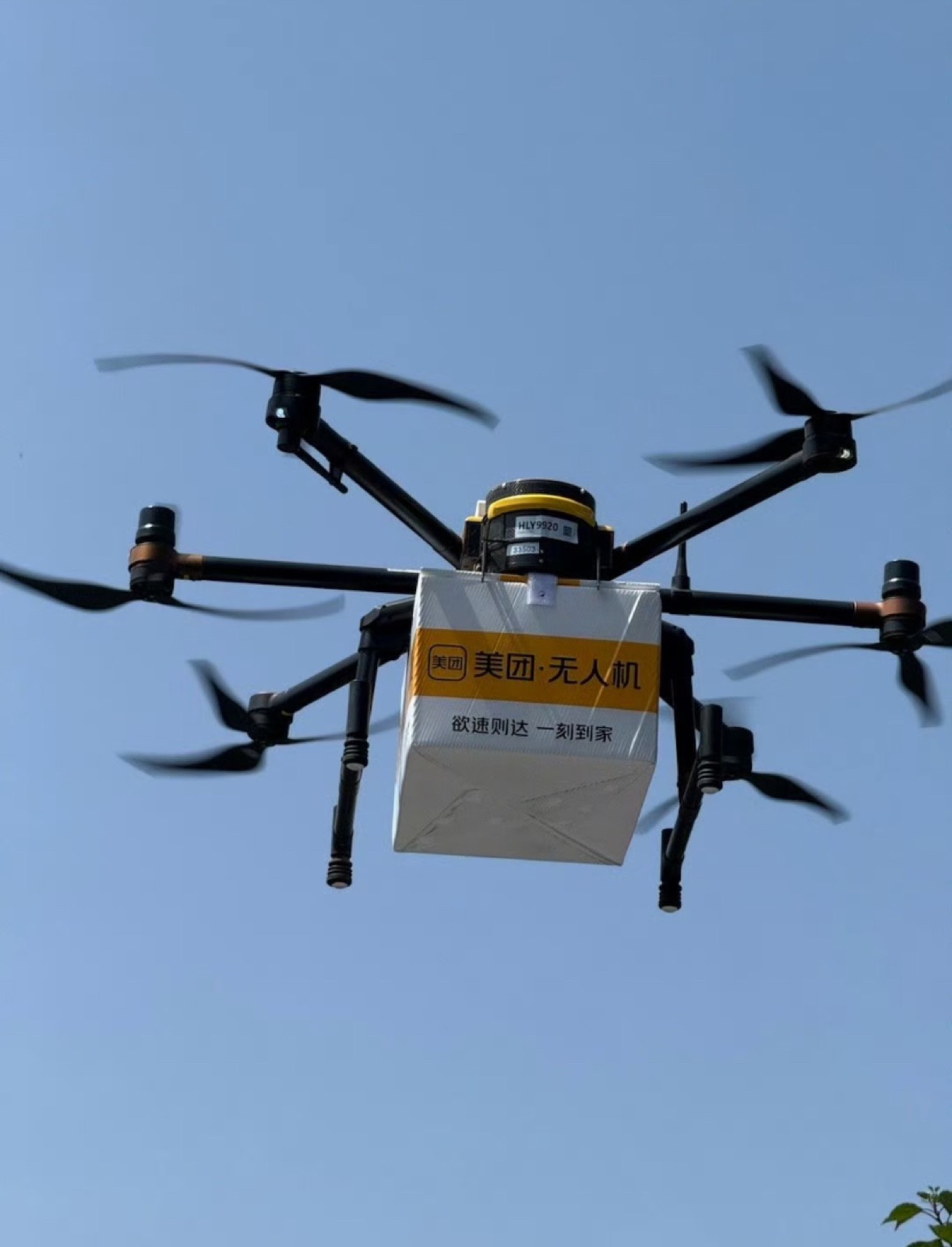 A delivery drone carrying a package through a blue sky