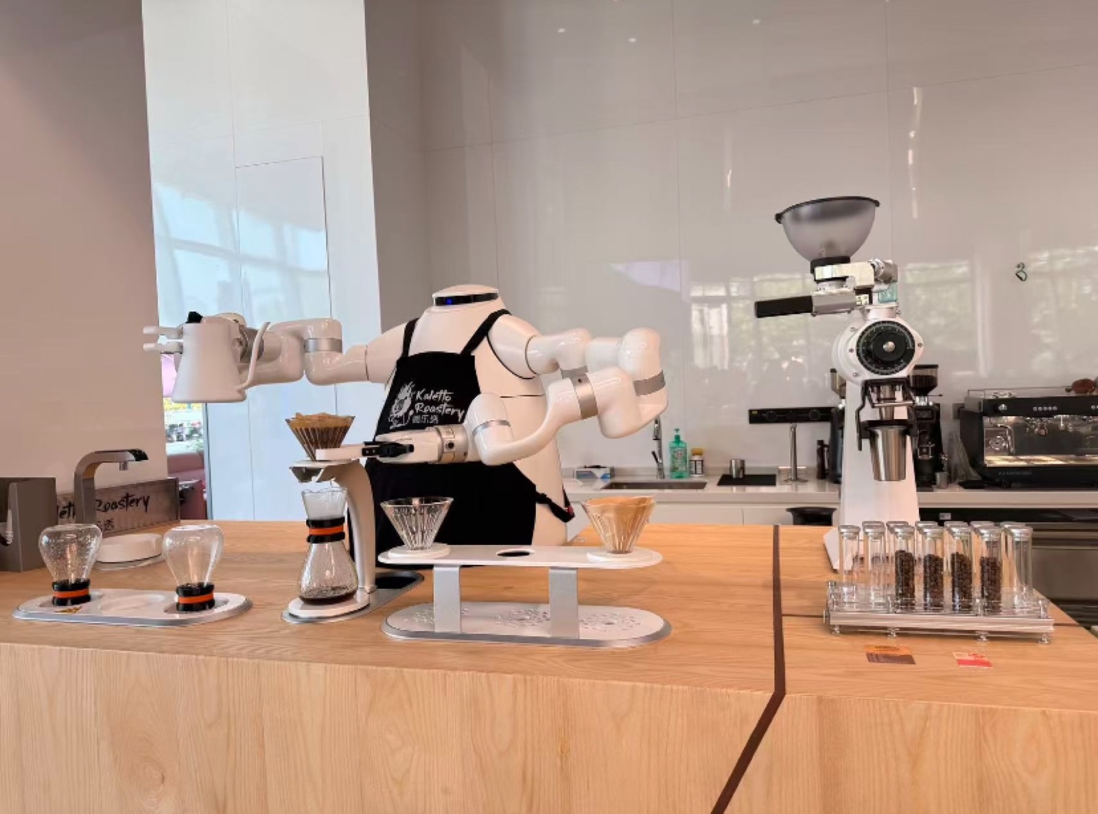 A robotic arm brewing pour-over coffee at a café counter