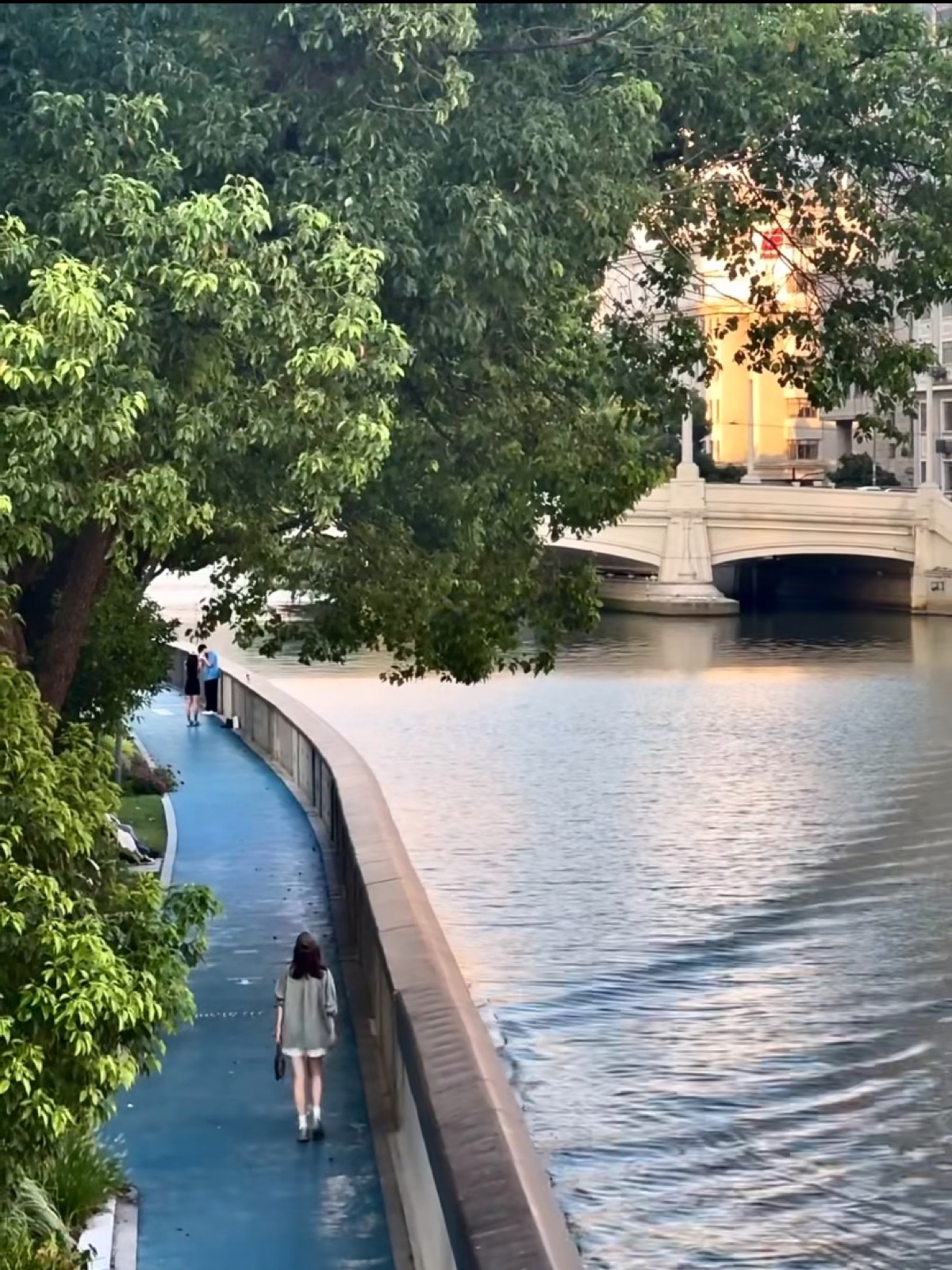 A walker on the revitalised riverside promenade along Suzhou Creek