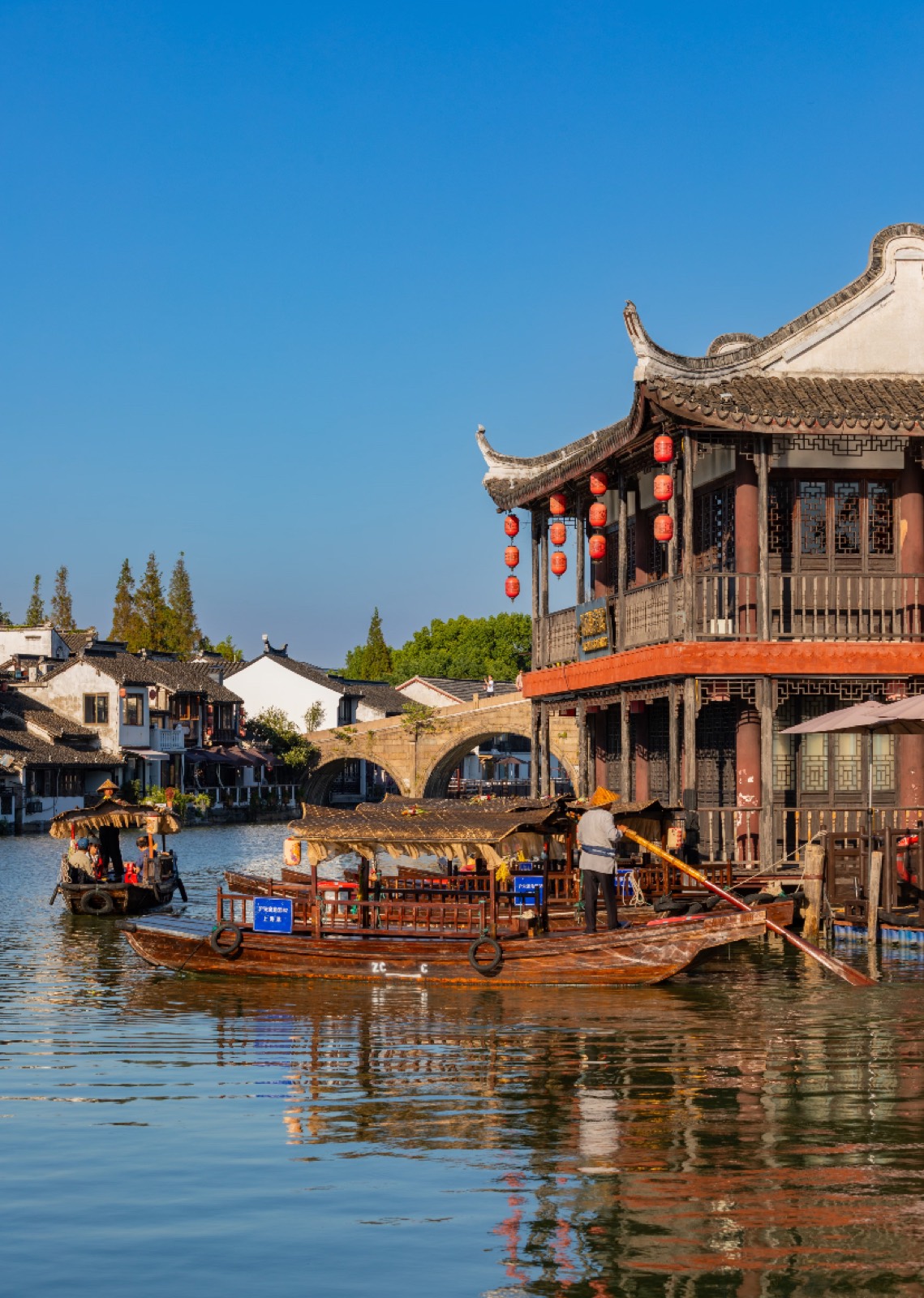 The arched Fangsheng Bridge with red lanterns and boats in Zhujiajiao