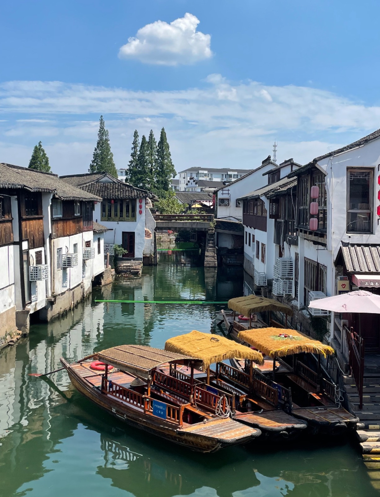 Wooden boats moored along a canal lined with whitewashed houses in Zhujiajiao