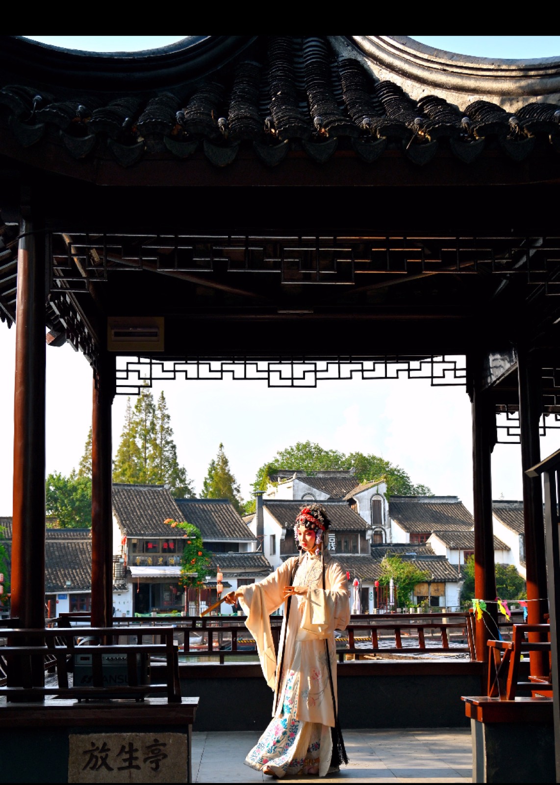 A performer in traditional costume at a pavilion in Zhujiajiao