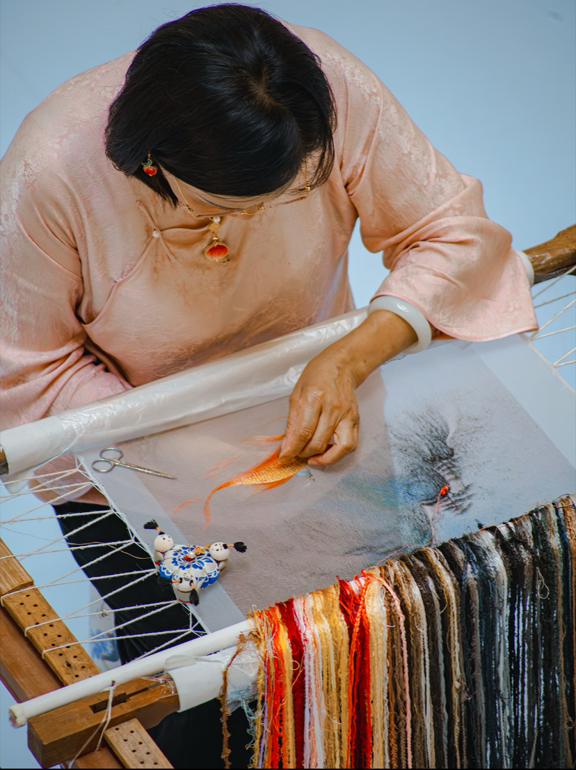 A Suzhou embroidery master at work over a silk frame