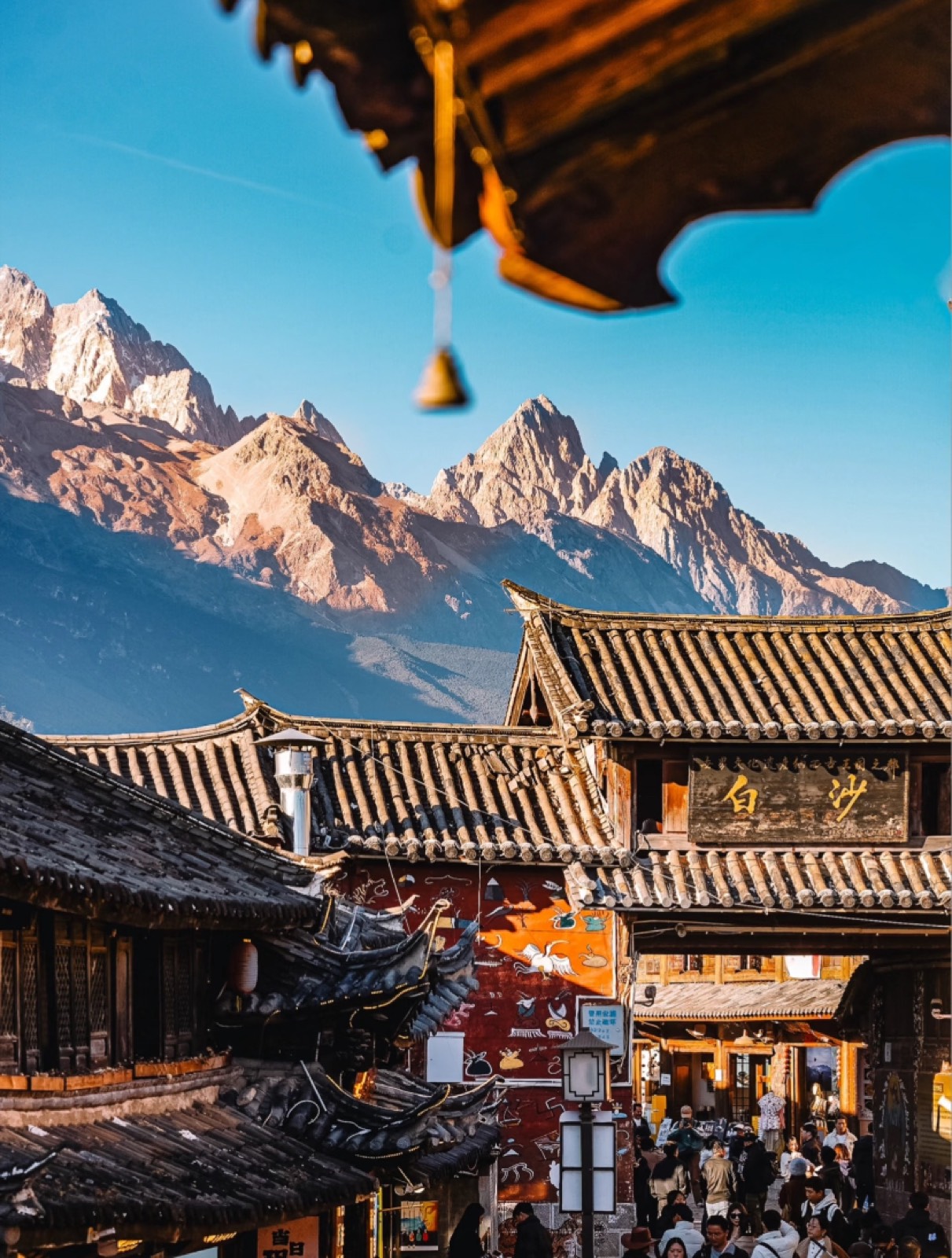 Lijiang's old-town rooftops layered beneath the snow-dusted peaks of Jade Dragon Snow Mountain