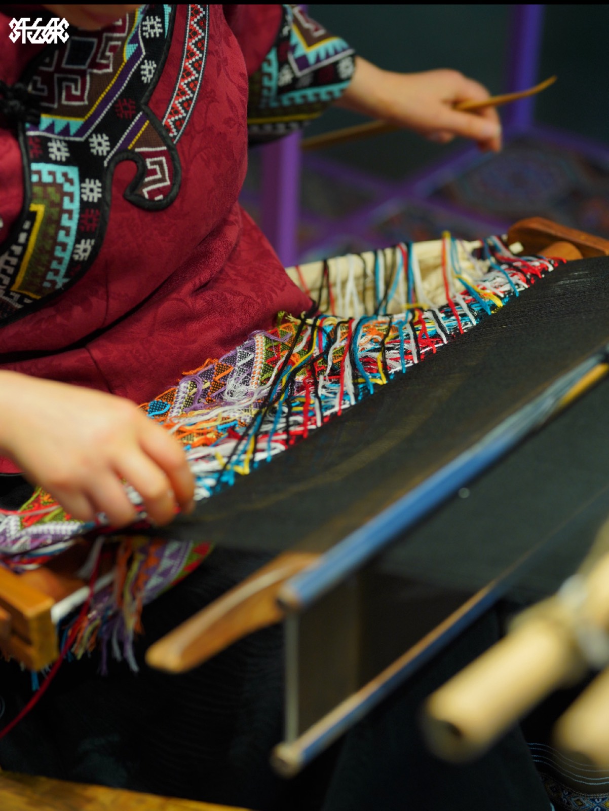 Tujia artisan weaving traditional brocade on a wooden loom